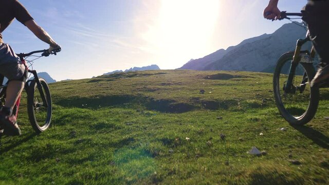 Close up - Mountain bikers arriving to the top of beautiful mountain in spring