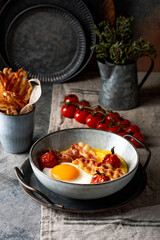 Cheesy breakfast polenta bowls with fried eggs, crispy bacon and roasted cherry tomatoes