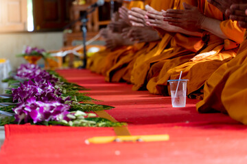 ฺBlurred of Monks chant along with holding the Sin line. There are orchids placed in front of the monks waiting to be delivered according to the Buddhist faith in Thailand.