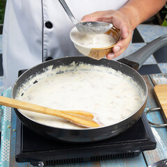 Chef spoon mushroom cream soup into a cup