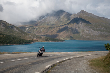 Motorcyclist leading towards a curve in alpine road of Mont Cenis, Italy