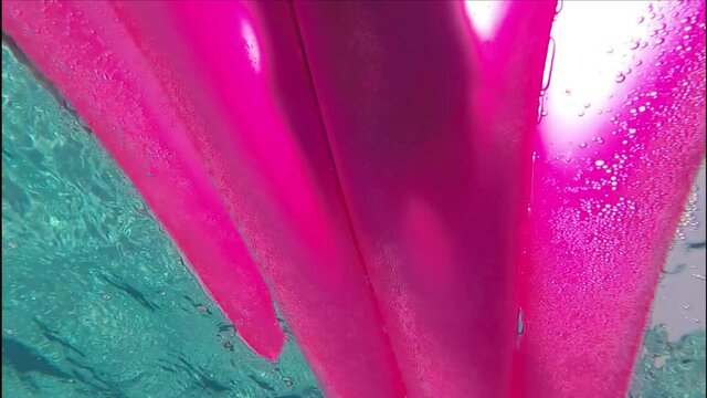 Outlines of a person on a rubber mattress in the pool, taken from the water below