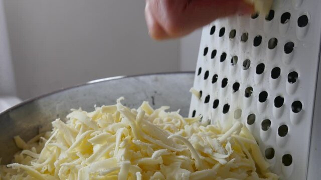 Chef grating cheese for pizza, close up