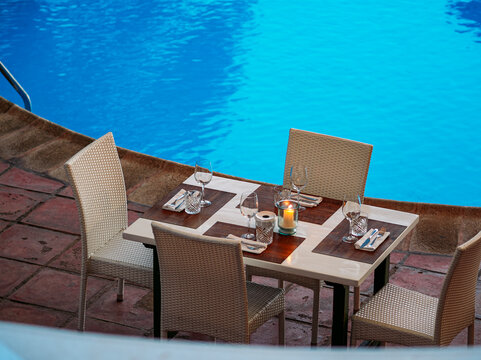 Mesa en la terraza con piscina de fondo

