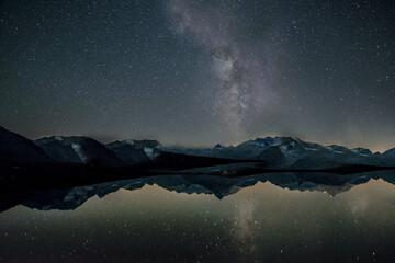 Night starry sky over mountains and lake.Texture or background