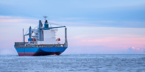 logistics and transportation concept.cargo ship import export commerce sail boat at sea at twilight sky