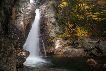 Beautiful waterfall in a deciduous forest in autumn. Glen Ellis falls, NH, USA.