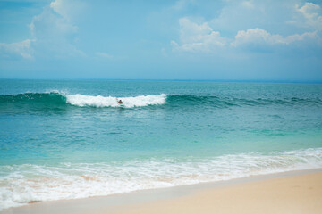 The guy is swimming on the surf board on the ocean. Healthy active lifestyle in summer vocation.