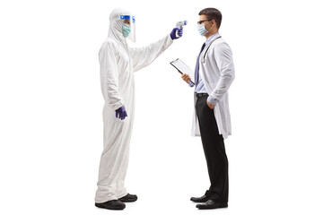 Full length profile shot of a man in a hazmat suit measuring temperature to a doctor