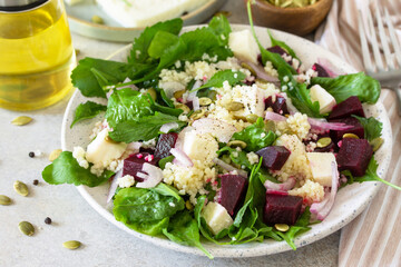 Healthy salad with couscous, soft cheese, beetroot and vinaigrette dressing.