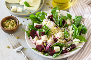 Healthy salad with couscous, soft cheese, beetroot and vinaigrette dressing.