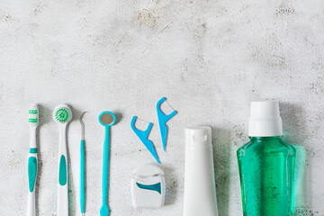 Toothbrush, mouthwash, dental floss and dental instruments for teeth hygiene top view on white concrete background.
