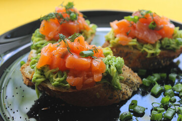 French loaf bruschetta with red fish, greens and avocado