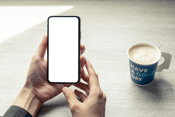 cell phone mockup image blank white screen.woman hand holding texting using mobile on desk at coffee shop.background empty space for advertise.work people contact marketing business,technology