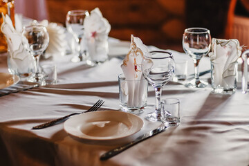 set of empty glasses and plates with Cutlery on a white tablecloth on the table in the restaurant