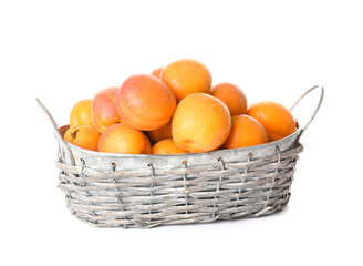 Basket with tasty ripe apricots on white background