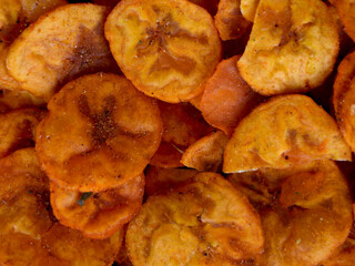 Orange color banana chips with hot red chili flavor as texture
