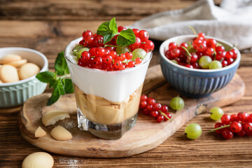 Refreshing cream cheese dessert with peanut butter and sponge biscuits, topped with fresh gooseberries and red currants