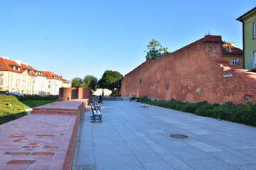 The historic defensive walls of the Warsaw Barbican and burgher houses in the Old Town in the light...