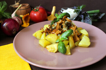 Fried potatoes with chanterelles on a plate and greens