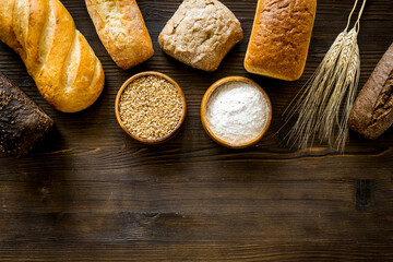 Bread near wheat ears and bowl of flour top-down space for text