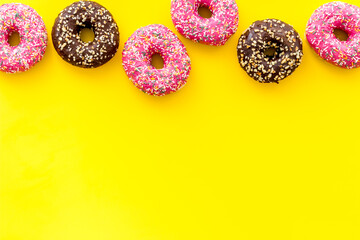Colorful donuts pink and chocolate icing. Flat lay of bakery, above view
