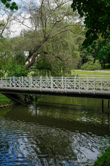 Fototapeta na wymiar romantic bridge over pond in Spa park in Naleczow, Poland