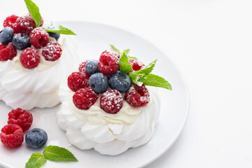 mini Pavlova dessert with raspberries and blueberries on the table