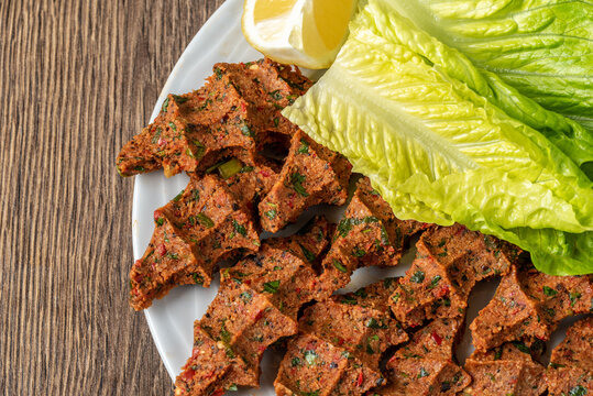 Cig kofte (raw meatball in Turkish) with lettuce and lemon. Turkish local raw food concept.
