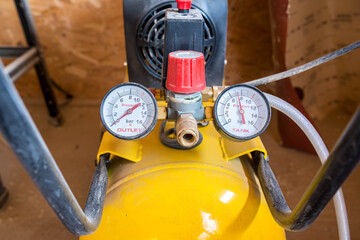 Dusty manometers on air compressor in a small wood workshop.