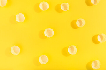Trendy pattern made with yellow cap on bright yellow background.