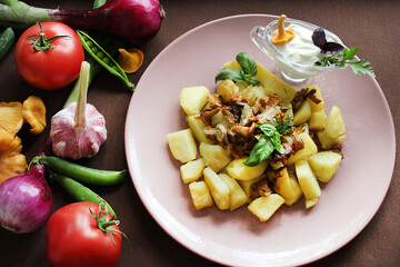 Fried chanterelles and potatoes with herbs and vegetables.Texture or background