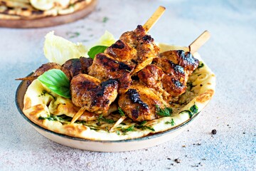 Grilled chicken kebabs (chicken skewers) with herbed garlic butter naan tortillas and Greek tzatziki sauce. Delicious street food.