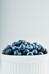Juicy Blueberries in a white Cup on a white background.