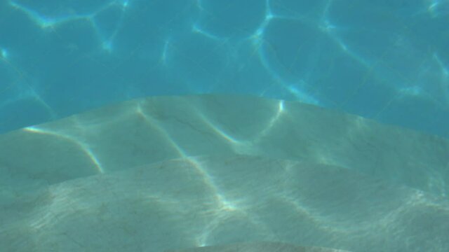 Fethiye, Turkey - 11th of June 2020: 4K Zoom out motion of sunlight effecting the water of swimming pool
