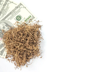 banknote lay under heap of tobacco on white background from overhead view with copy space. concept for tobacco trading.