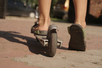 Obraz premium Little Boy Riding Scooter In The City