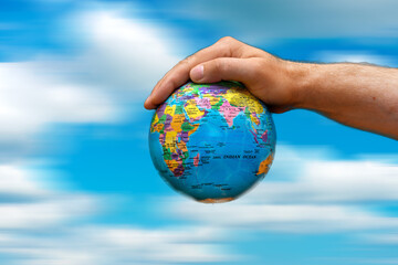 Conceptual symbol human hands surrounding the Earth world globe. the sky in motion