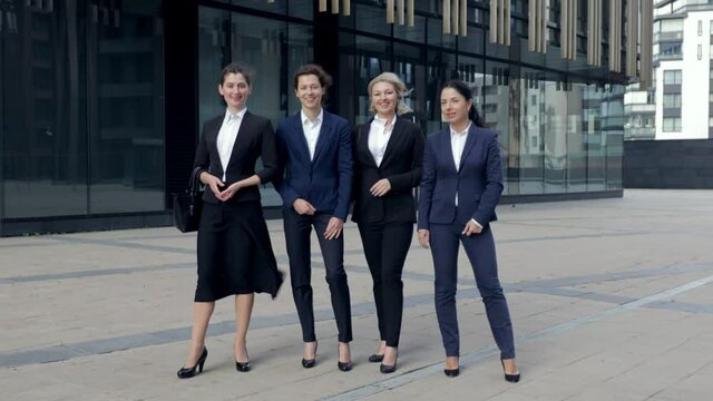 Four business women smilingl ooking at camera