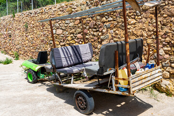 Fototapeta premium Old green tractor adapted with a trailer to carry passengers and garden tools