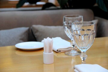 empty table in the cafeteria. two crystal glasses for water and wine on the table.