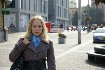 Fototapeta na wymiar Beautiful blonde girl in the city. Sunny day. Business woman