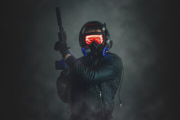 Futuristic soldier with the rifle on dark background.