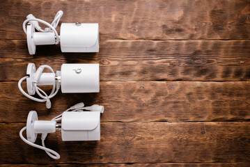 Modern white security cameras on the table background. Video surveillance concept background.