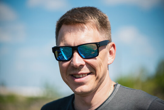 Smiling man in sunglasses close up.