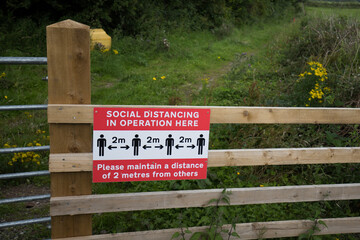 Social distancing sign at a popular tourist spot in the Ribble Valley. Warning sign during the Covid-19 pandemic