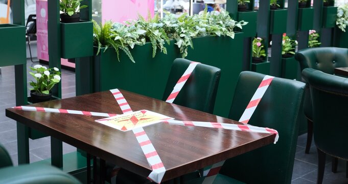 Cafe (cafeteria) in the pandemic. Work of cafes and restaurants with respect to social distance. Seating in the cafe. Tables and chairs in a cafe/restaurant with red-white tape.
