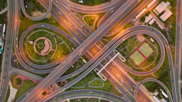 Day to Night time lapse of Urban aerial freeway intersection and highway traffic at night