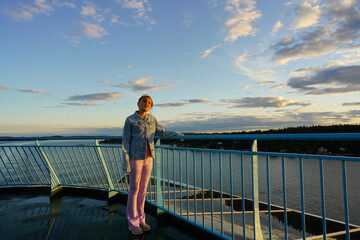 Young girl on a ferry between Stocholm and Turku. Sunset and beatiful sky.