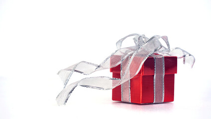 Red gift box with glitter ribbon on white background